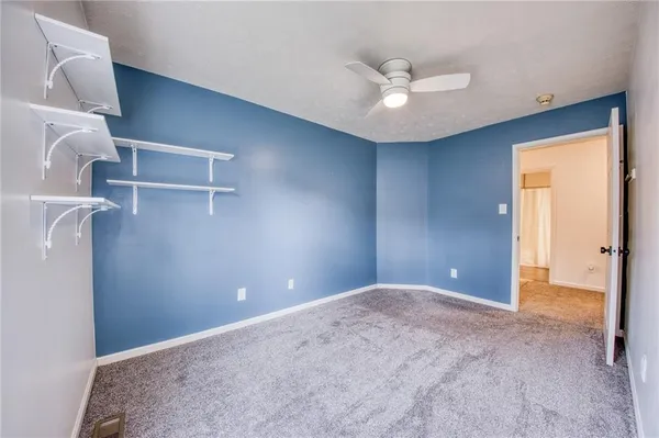 a view of a livingroom with a ceiling fan and window