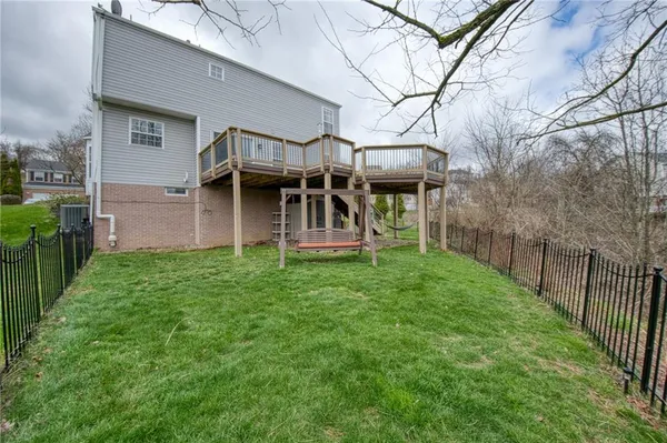 a view of a house with a yard and wooden fence