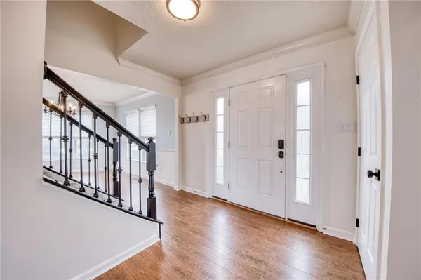 a view of a hallway with wooden floor and staircase
