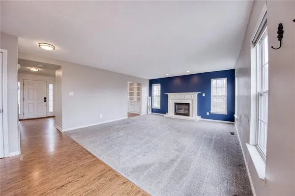 a view of empty room with wooden floor and fireplace