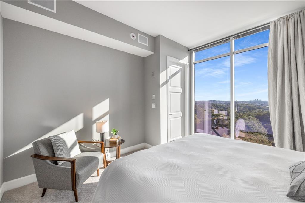 1820 Peachtree Road Northwest, Unit 1205 Atlanta, GA 30309 - Photo 25 of 51 a bedroom with a bed and a large window