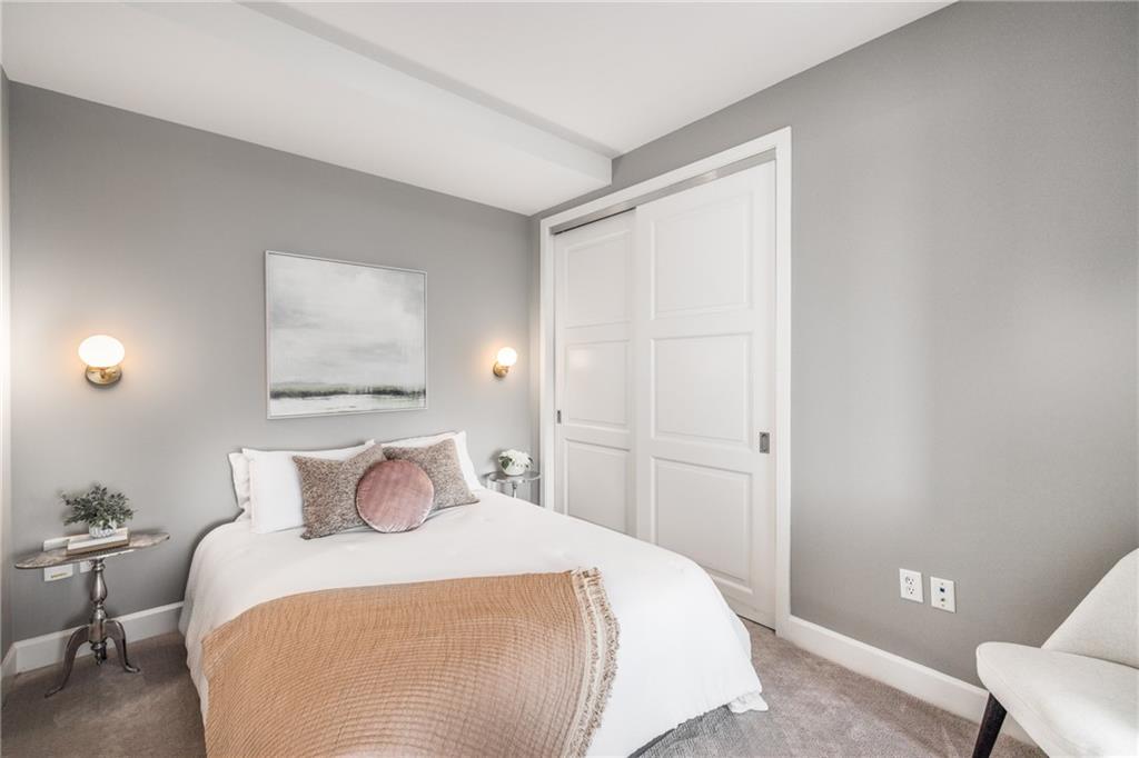 1820 Peachtree Road Northwest, Unit 1205 Atlanta, GA 30309 - Photo 30 of 51 a bedroom with a bed and a painting on the wall