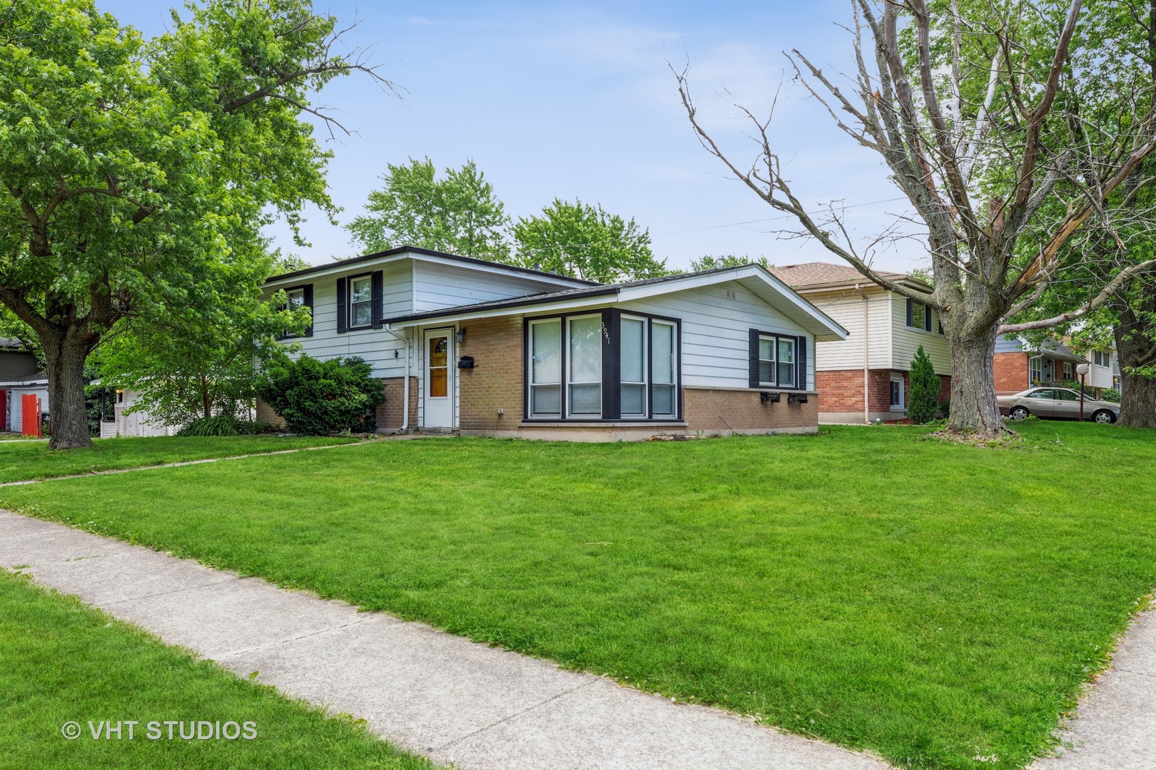 3941 169th Street Country Club Hills, IL 60478 - Photo 2 of 22 a view of a house with a big yard plants and large trees