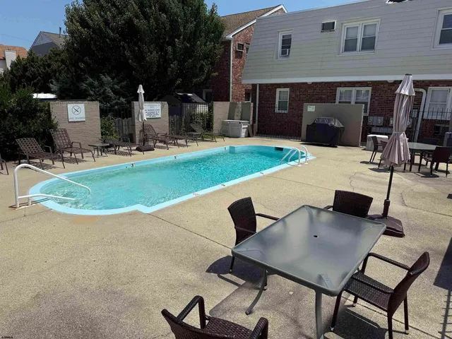 a view of a patio with table and chairs a barbeque grill with wooden fence