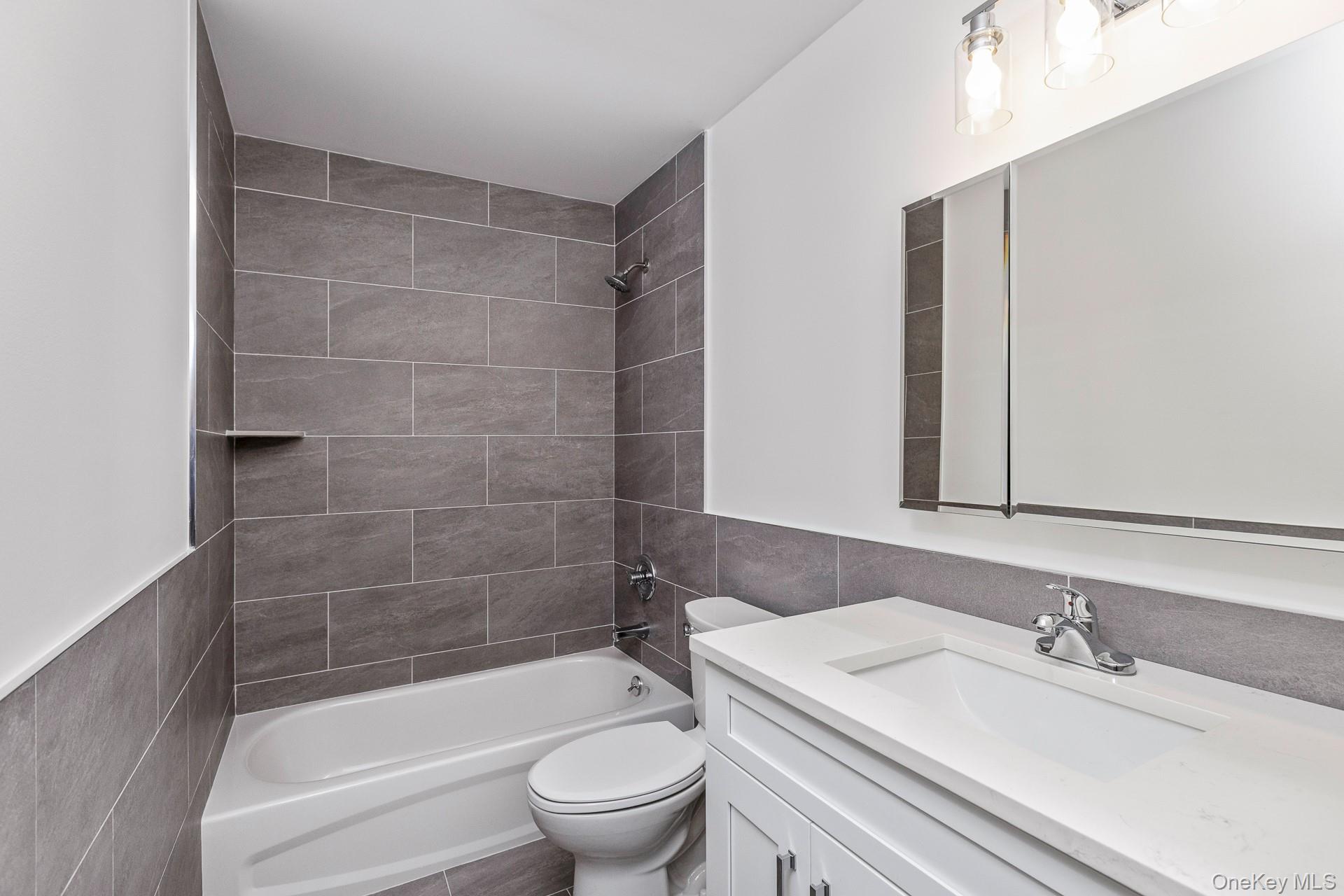 92 Park Street Blue Point, NY 11715 - Photo 16 of 32 Bathroom featuring shower / bathtub combination, vanity, and tile walls