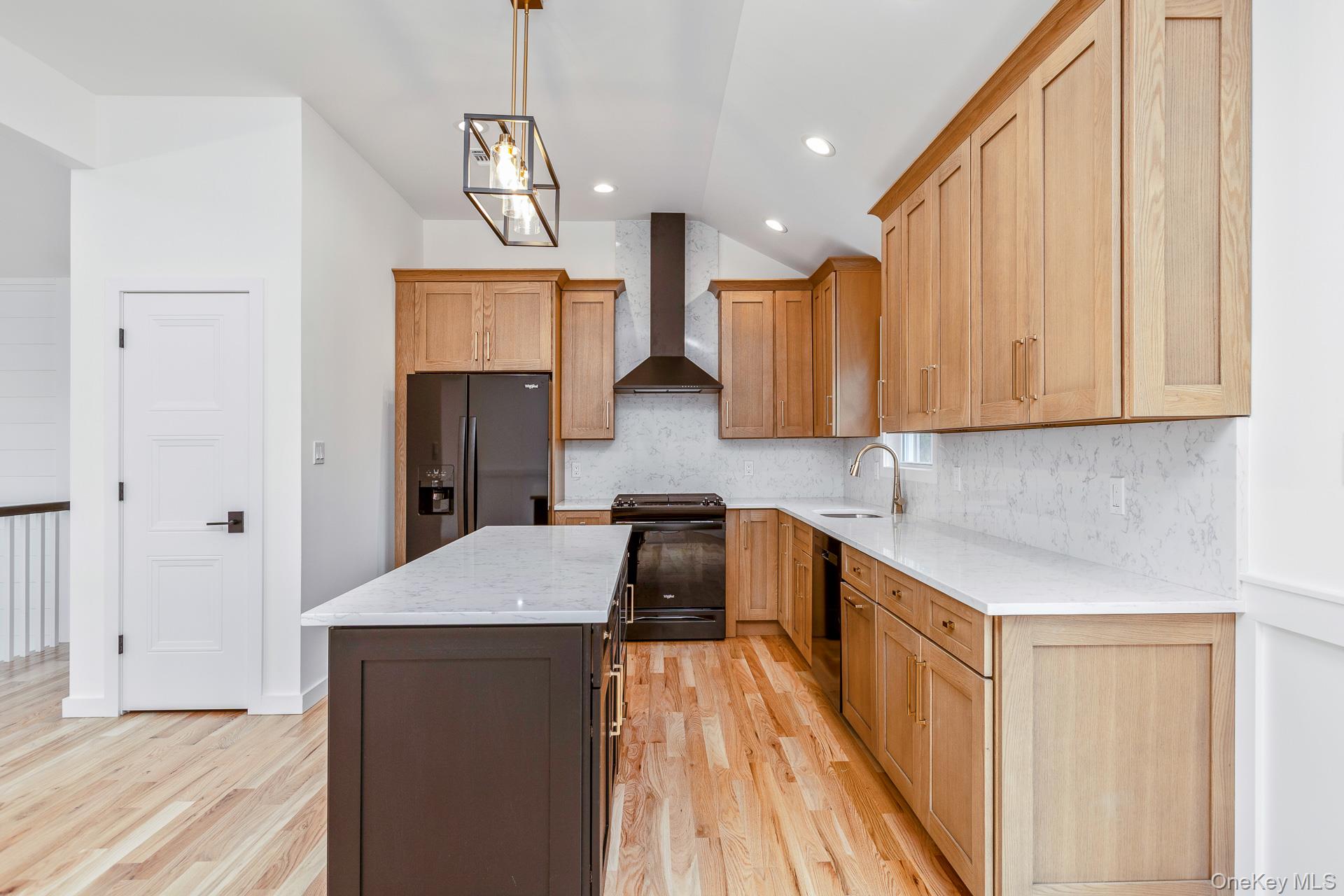 92 Park Street Blue Point, NY 11715 - Photo 23 of 32 Kitchen featuring pendant lighting, light stone counters, a kitchen island, vaulted ceiling, and backsplash