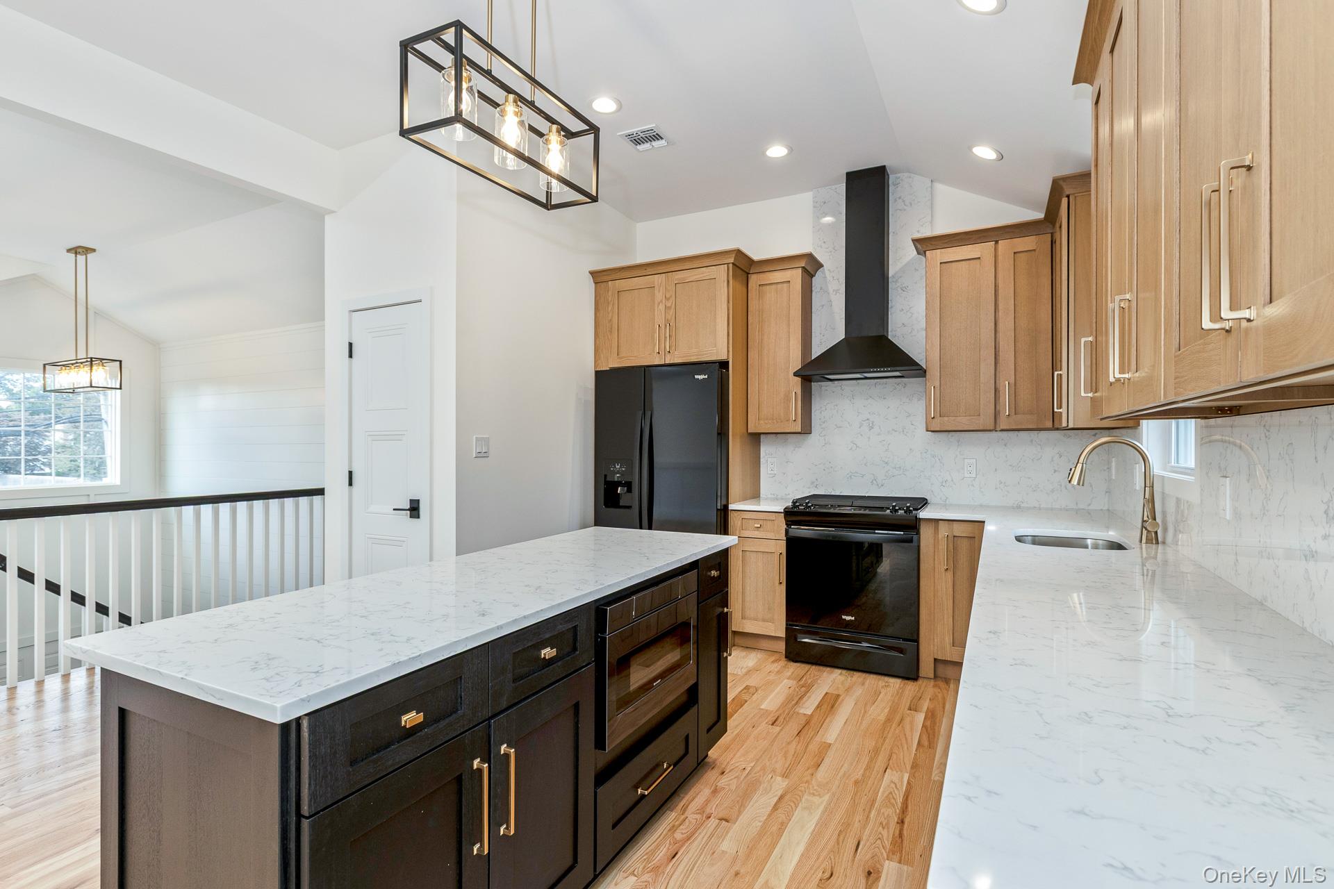 92 Park Street Blue Point, NY 11715 - Photo 25 of 32 Kitchen featuring light stone counters, decorative light fixtures, vaulted ceiling, black appliances, and wall chimney range hood