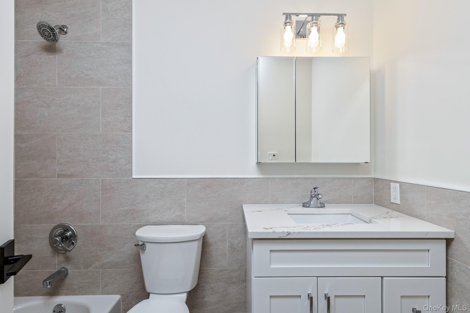 92 Park Street Blue Point, NY 11715 - Photo 27 of 32 Bathroom with shower combination, vanity, and tile walls