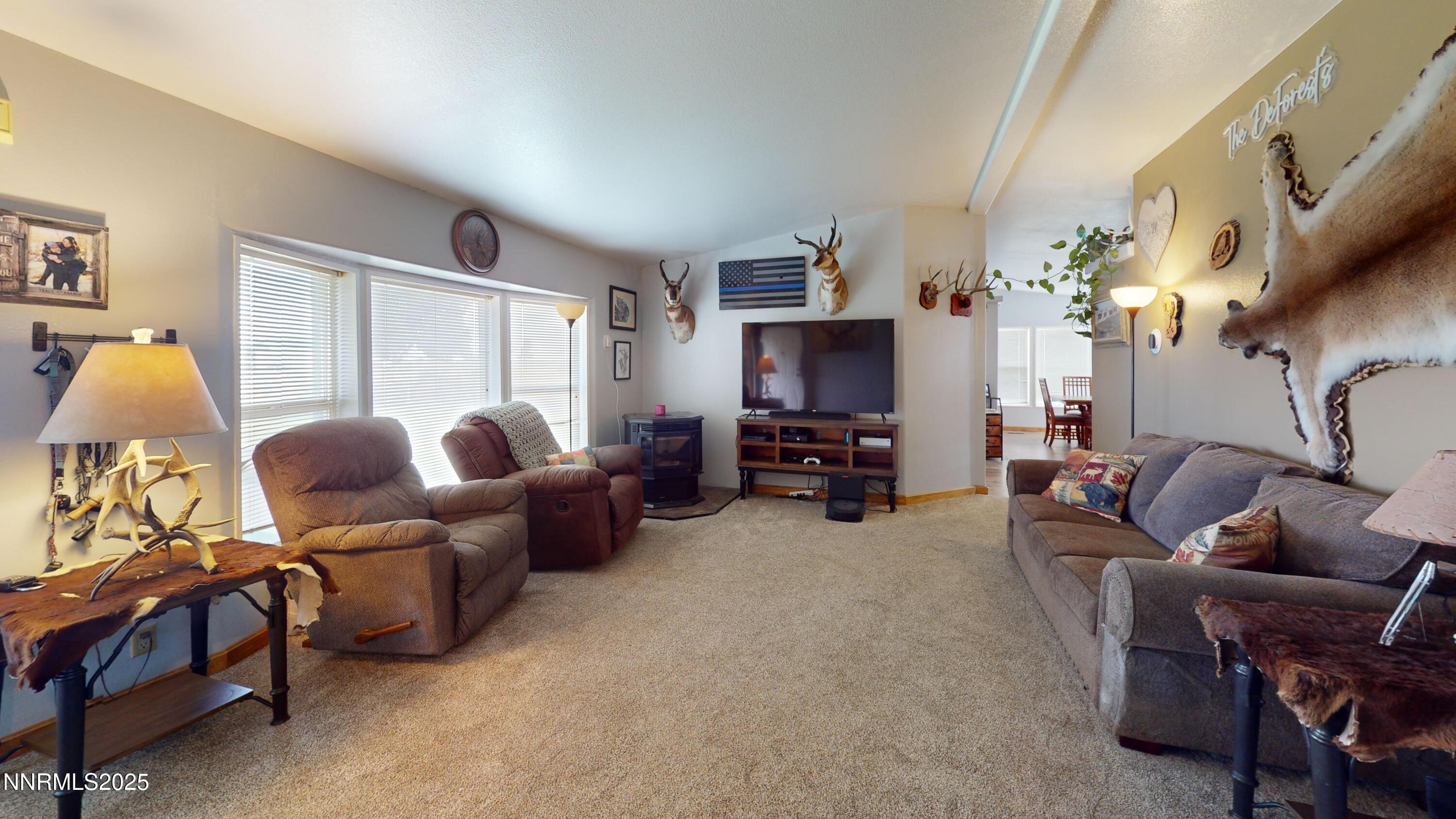 8425 Styles Court Winnemucca, NV 89445 - Photo 4 of 27 a living room with furniture a chandelier and a fireplace