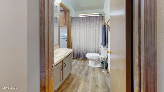 a bathroom with a granite countertop sink a toilet and a shower