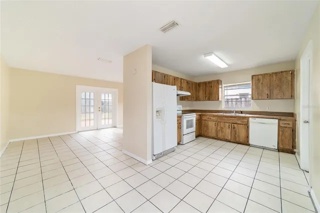 a kitchen with a cabinets a sink a window and stainless steel appliances