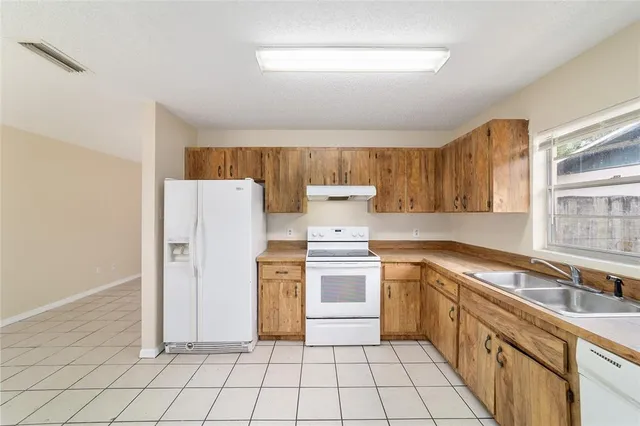 a kitchen with a stove a sink and a refrigerator