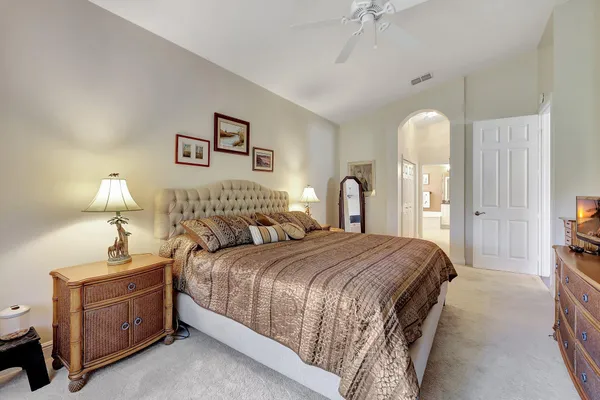a spacious bedroom with a bed and a flat screen television