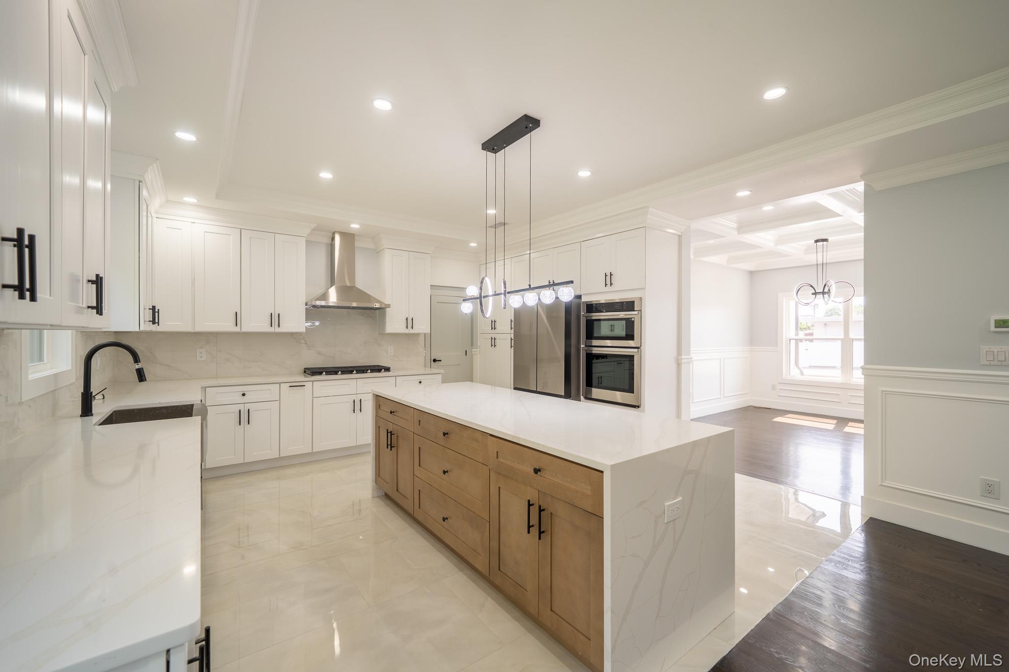770 Cedar Street Syosset, NY 11791 - Photo 12 of 35 Kitchen with a decorative wall, a wainscoted wall, coffered ceiling, a center island, and crown molding