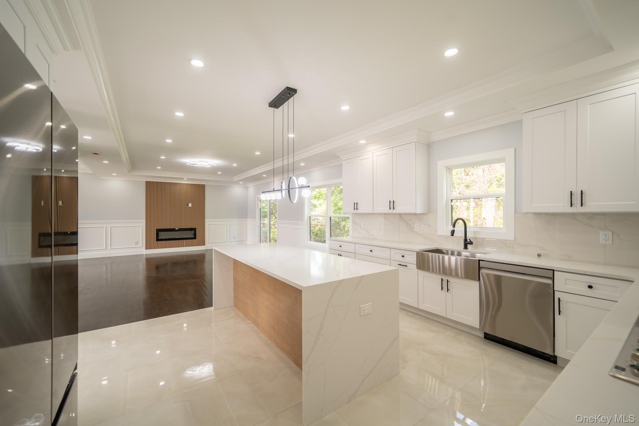 770 Cedar Street Syosset, NY 11791 - Photo 15 of 35 Kitchen featuring a decorative wall, a wainscoted wall, stainless steel appliances, crown molding, and light stone counters
