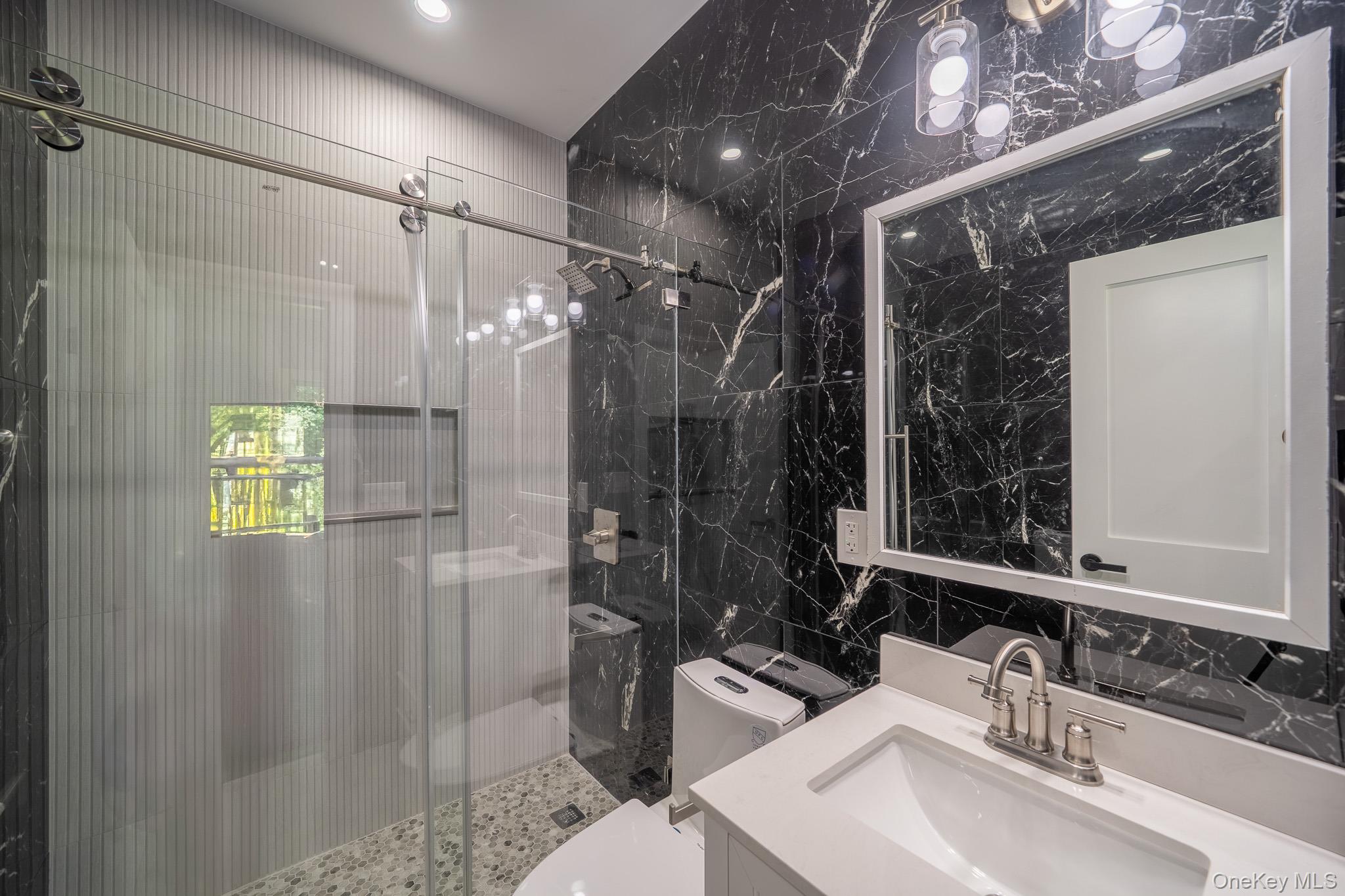 770 Cedar Street Syosset, NY 11791 - Photo 18 of 35 Bathroom featuring tile walls, a stall shower, and vanity
