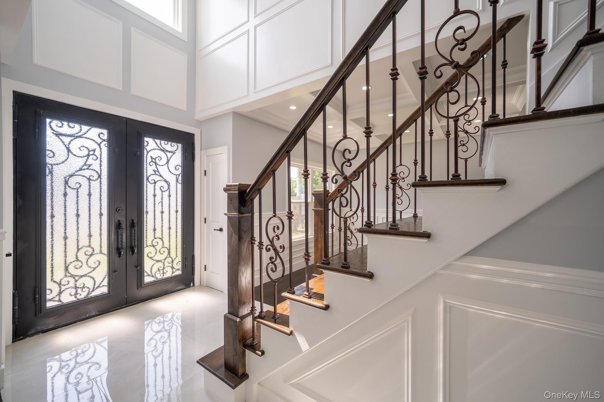 770 Cedar Street Syosset, NY 11791 - Photo 19 of 35 Foyer entrance with healthy amount of natural light, french doors, and a decorative wall