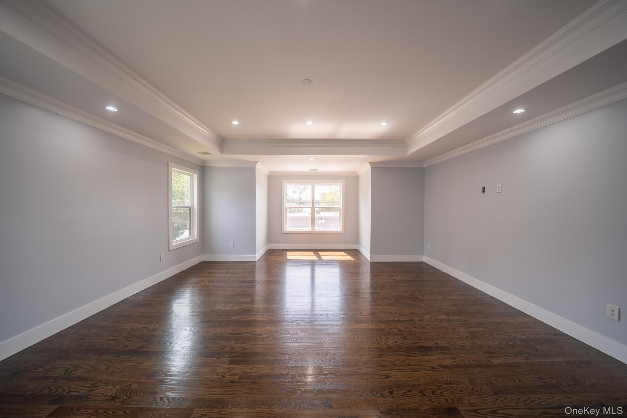 770 Cedar Street Syosset, NY 11791 - Photo 23 of 35 Unfurnished room featuring recessed lighting, dark wood-type flooring, ornamental molding, and a tray ceiling