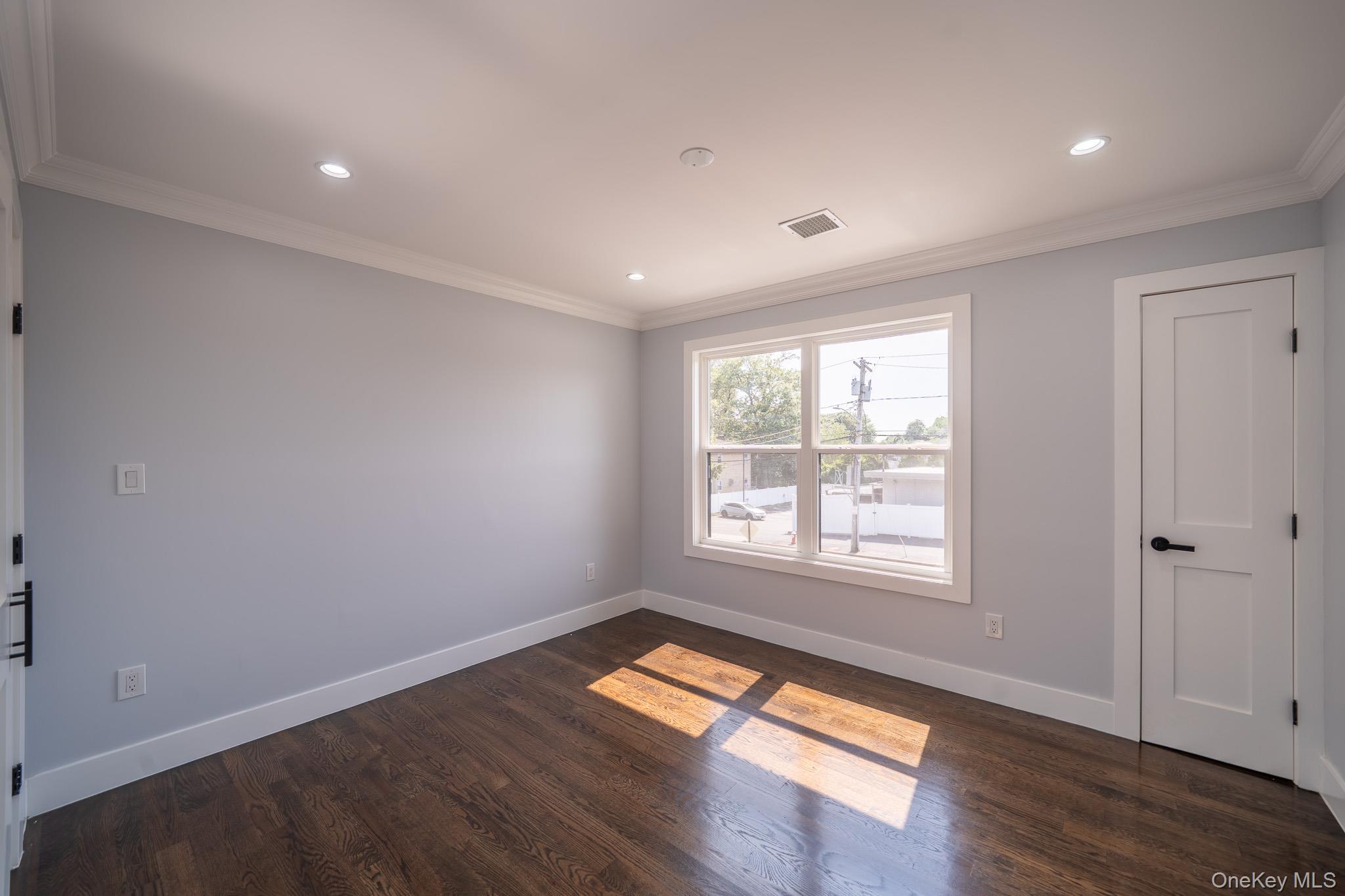770 Cedar Street Syosset, NY 11791 - Photo 28 of 35 Unfurnished room featuring crown molding, dark wood-type flooring, and recessed lighting