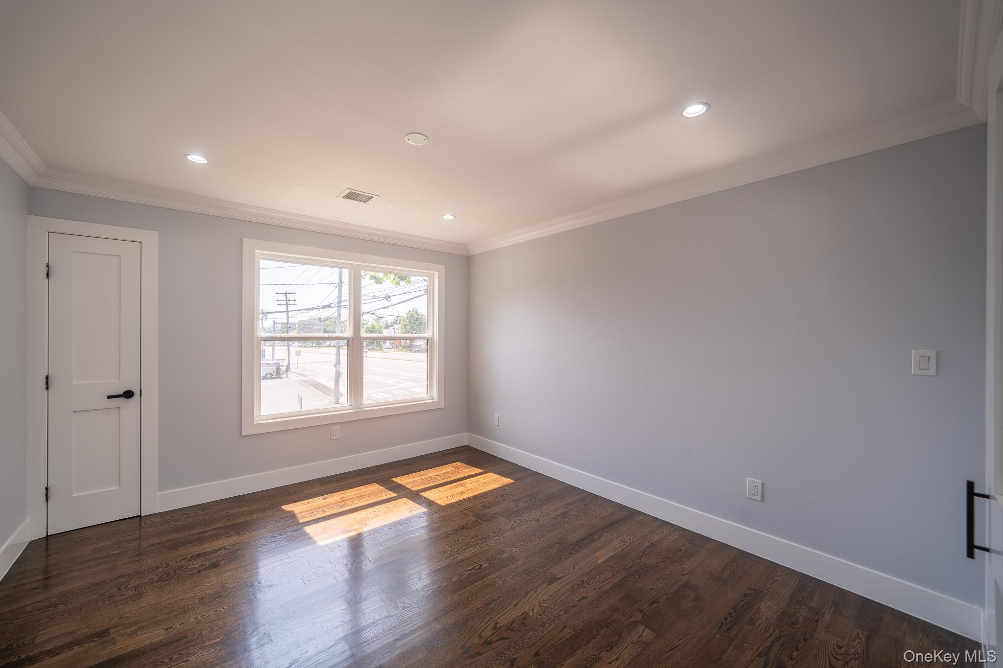 770 Cedar Street Syosset, NY 11791 - Photo 29 of 35 Spare room with dark wood-style flooring, crown molding, and recessed lighting
