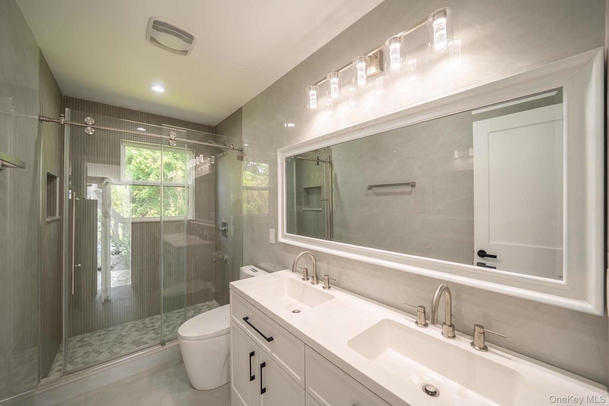 770 Cedar Street Syosset, NY 11791 - Photo 31 of 35 Bathroom with a shower stall and double vanity