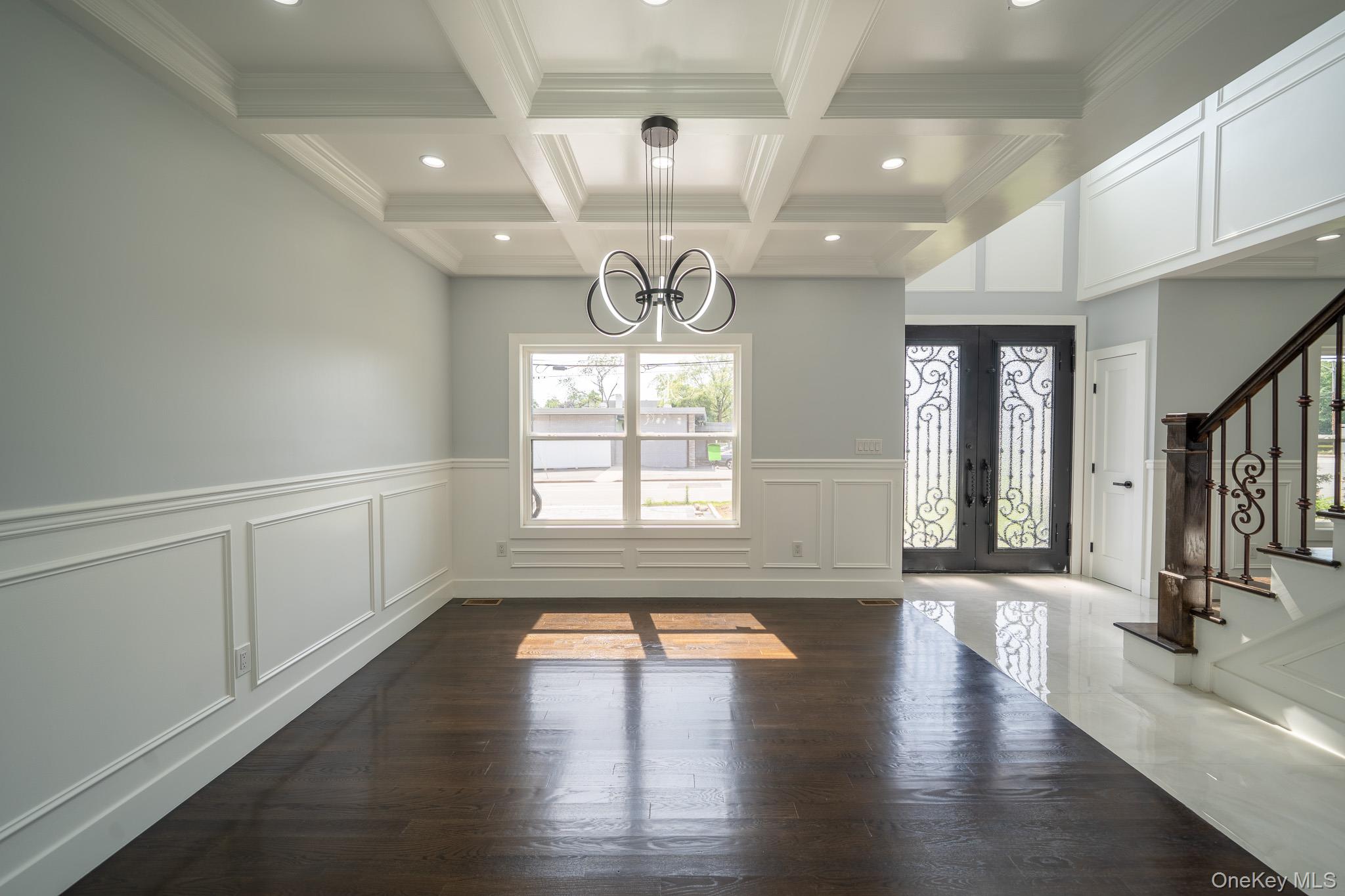 770 Cedar Street Syosset, NY 11791 - Photo 6 of 35 Unfurnished dining area with french doors, a chandelier, dark wood-style flooring, stairway, and beamed ceiling