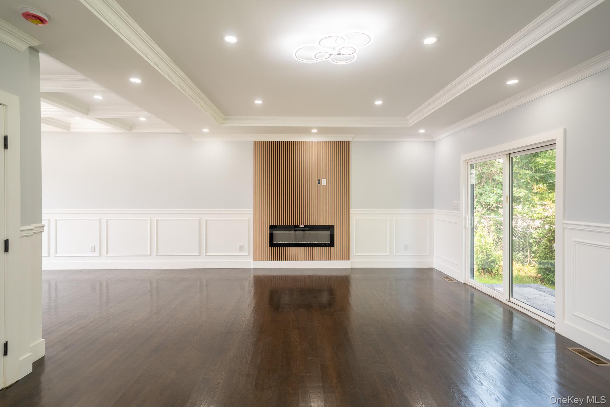 770 Cedar Street Syosset, NY 11791 - Photo 7 of 35 Unfurnished room featuring a decorative wall, a wainscoted wall, wood finished floors, crown molding, and recessed lighting