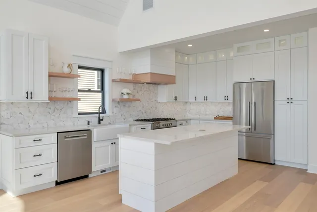 a kitchen with stainless steel appliances granite countertop white cabinets and a stove