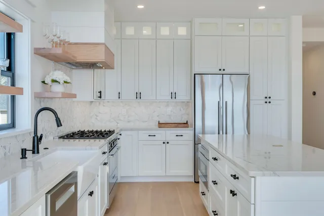 a spacious bathroom with a tub a double vanity sink and large windows