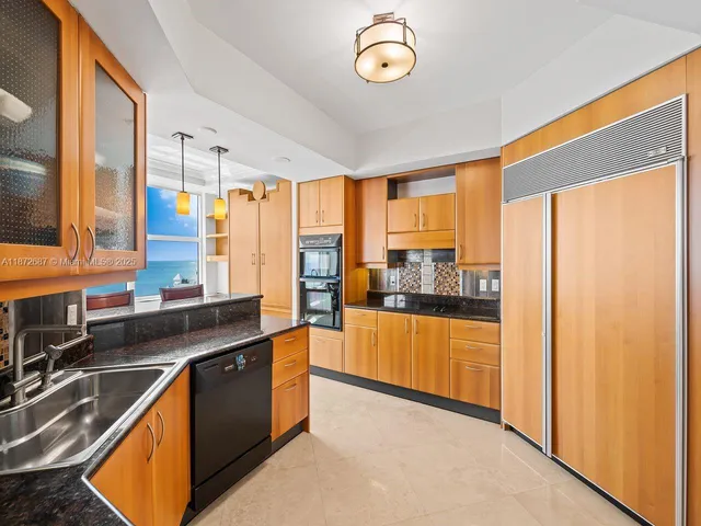 a kitchen with a table chairs refrigerator and a sink
