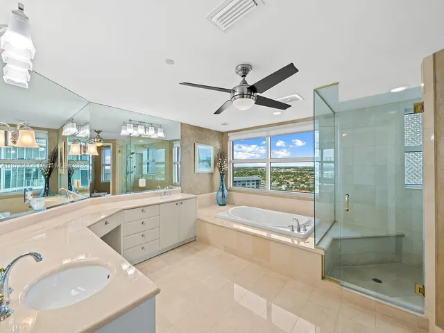 a large white bathroom with a large tub sink shower and mirror