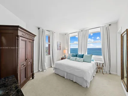 a spacious bedroom with a large bed and a flat tv screen on dresser