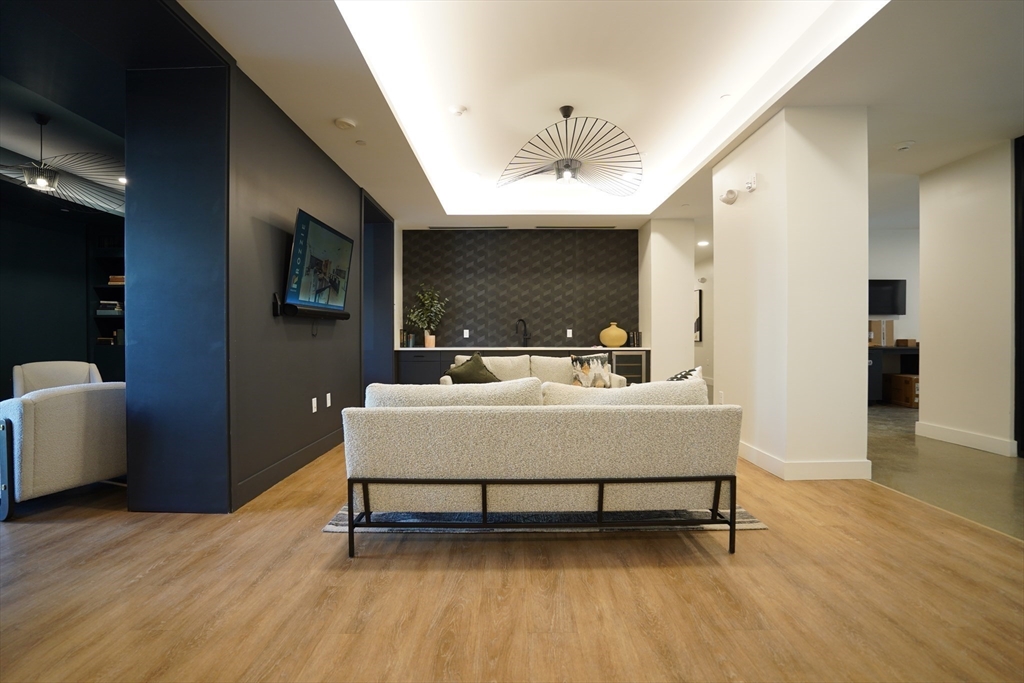289 Walk Hill Street, Unit 327 Boston, MA 02131 - Photo 2 of 31 a living room with furniture and a flat screen tv