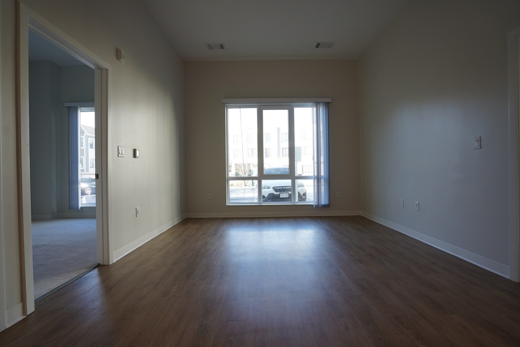 289 Walk Hill Street, Unit 327 Boston, MA 02131 - Photo 23 of 31 an empty room with wooden floor and windows