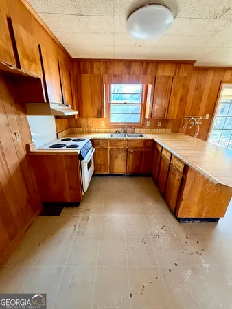 a kitchen with stainless steel appliances granite countertop a sink dishwasher stove and cabinets