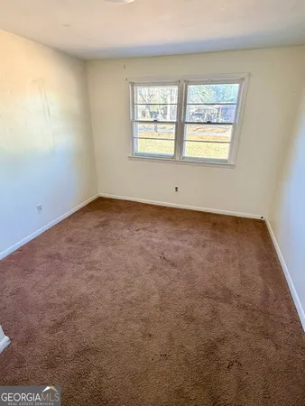 a view of an empty room with a window and a fireplace