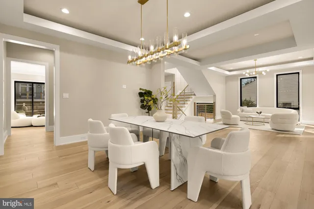 a kitchen with stainless steel appliances kitchen island granite countertop a stove a sink a refrigerator and white cabinets with wooden floor