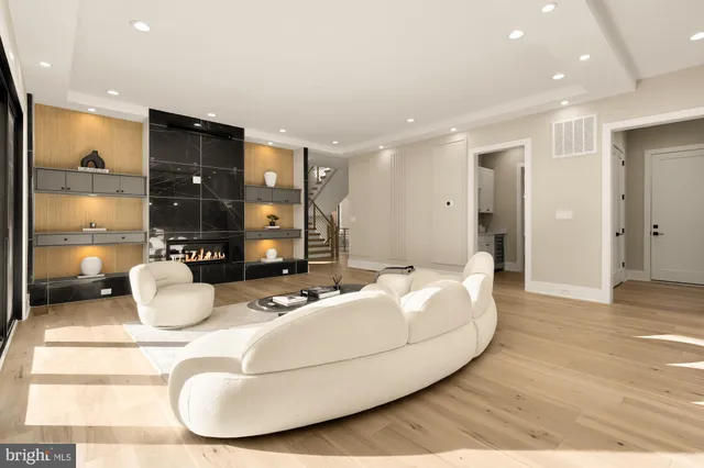 a kitchen with stainless steel appliances kitchen island granite countertop a refrigerator a oven and white cabinets with wooden floor