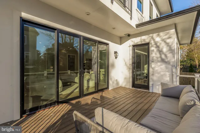a view of a hallway with wooden floor and a bathroom