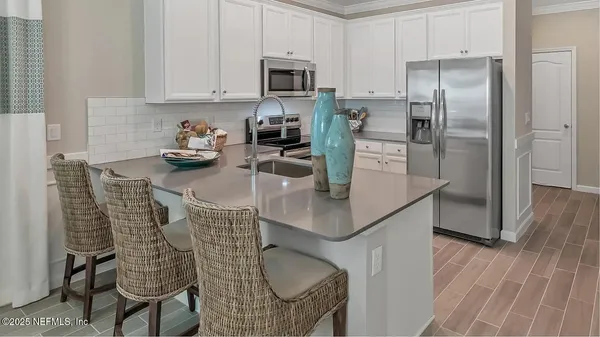 a kitchen with stainless steel appliances granite countertop a sink refrigerator and cabinets