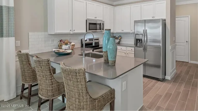 a kitchen with stainless steel appliances granite countertop a sink refrigerator and cabinets
