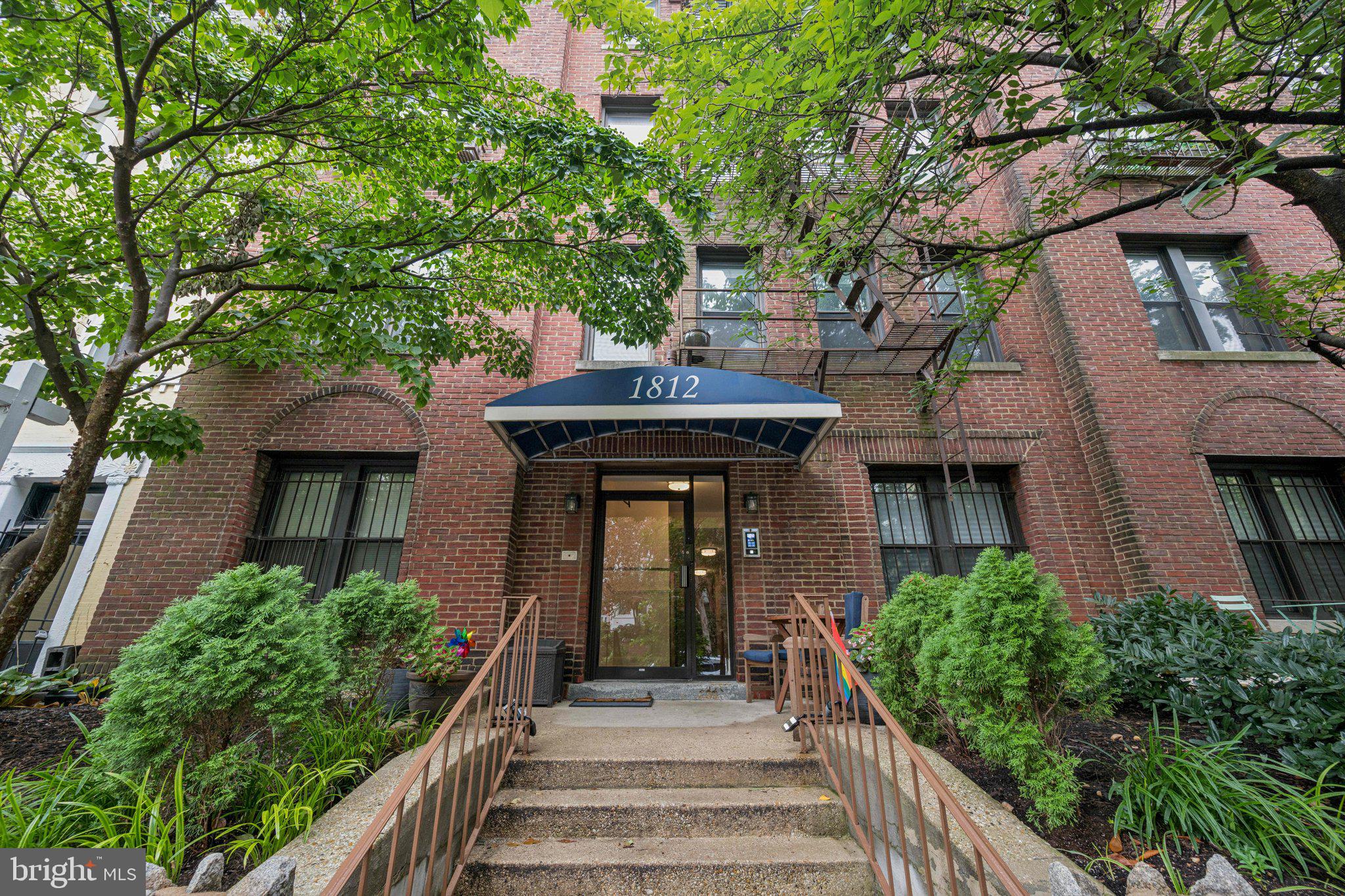 a view of a house with brick walls and a large tree