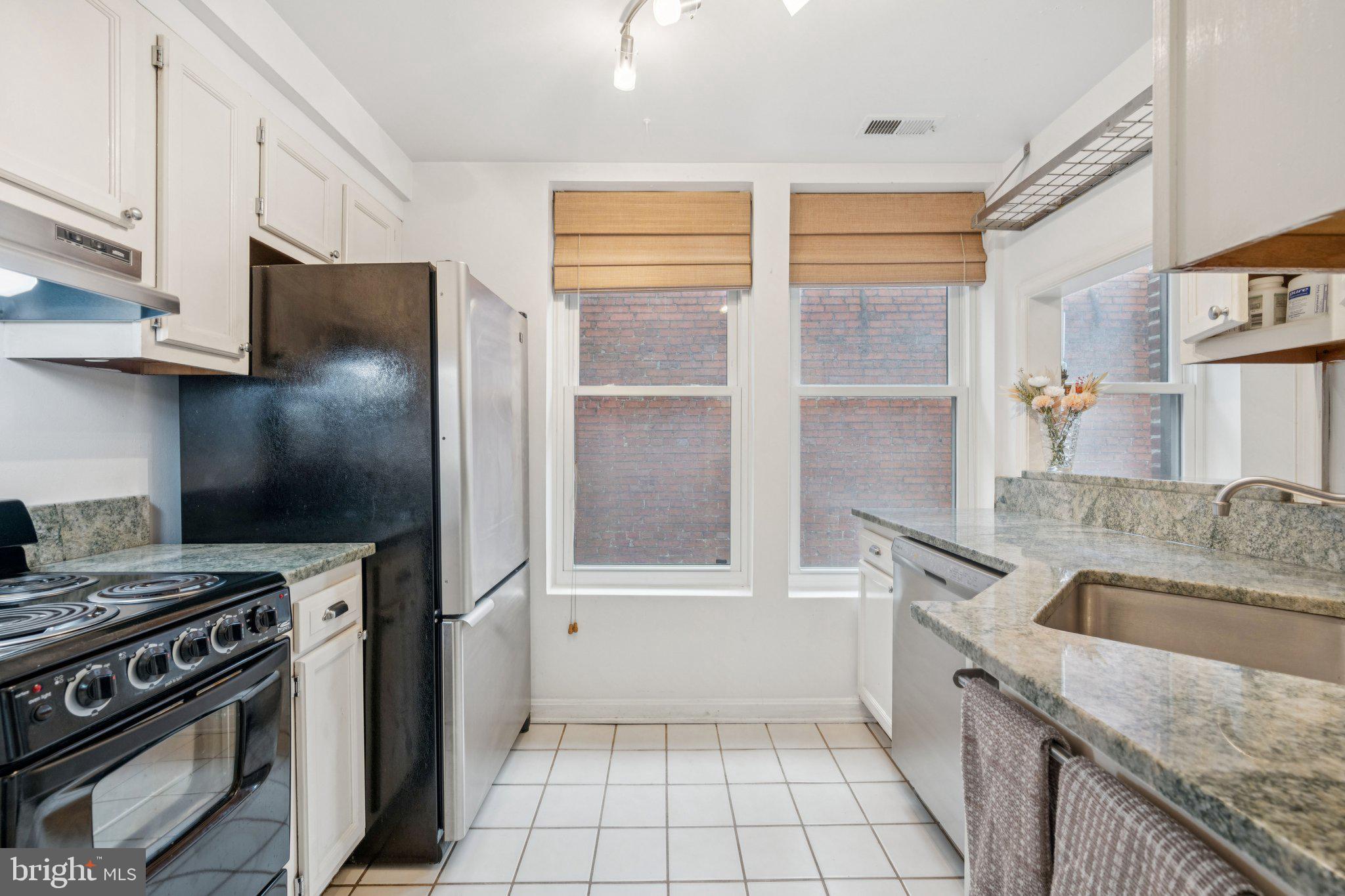 1812 Vernon Street Northwest, Unit 34 Washington, DC 20009 - Photo 10 of 26 a kitchen with granite countertop a sink stove and refrigerator