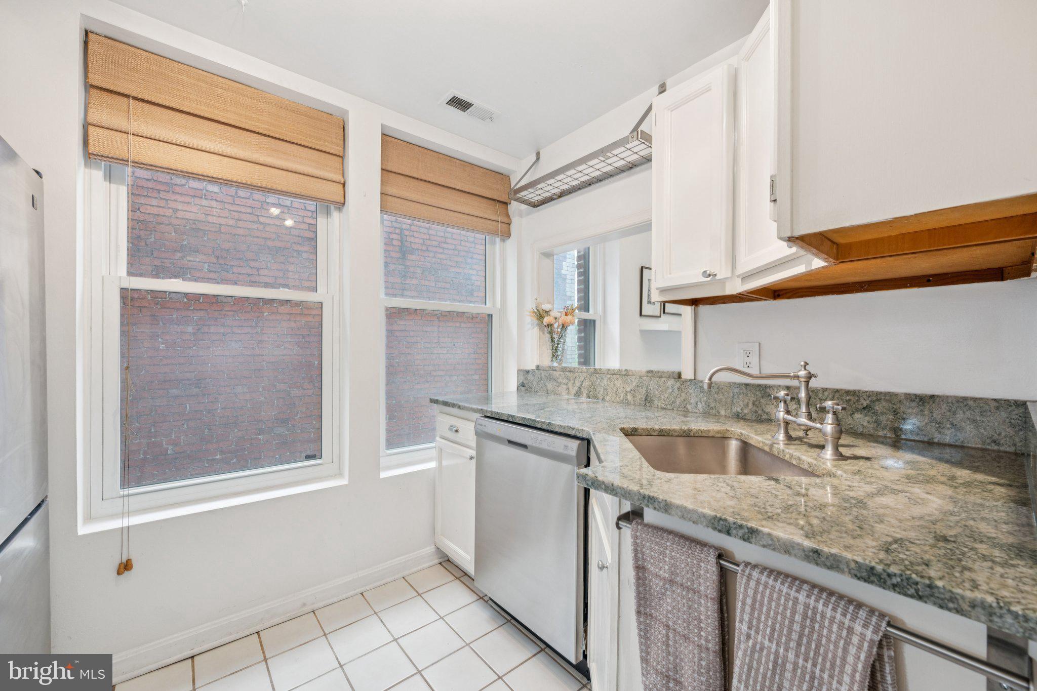 1812 Vernon Street Northwest, Unit 34 Washington, DC 20009 - Photo 11 of 26 a kitchen with a sink stove and cabinets
