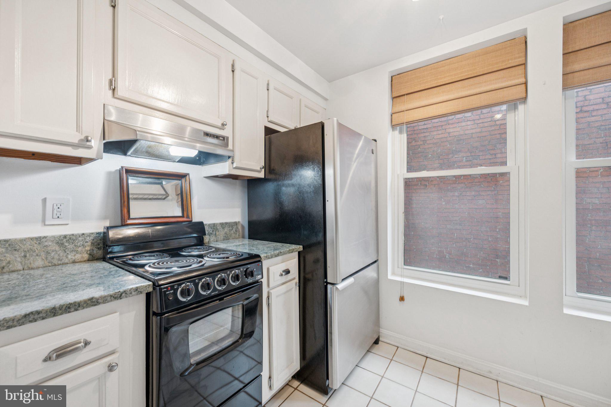 1812 Vernon Street Northwest, Unit 34 Washington, DC 20009 - Photo 12 of 26 a kitchen with stainless steel appliances granite countertop a stove a refrigerator and a cabinets