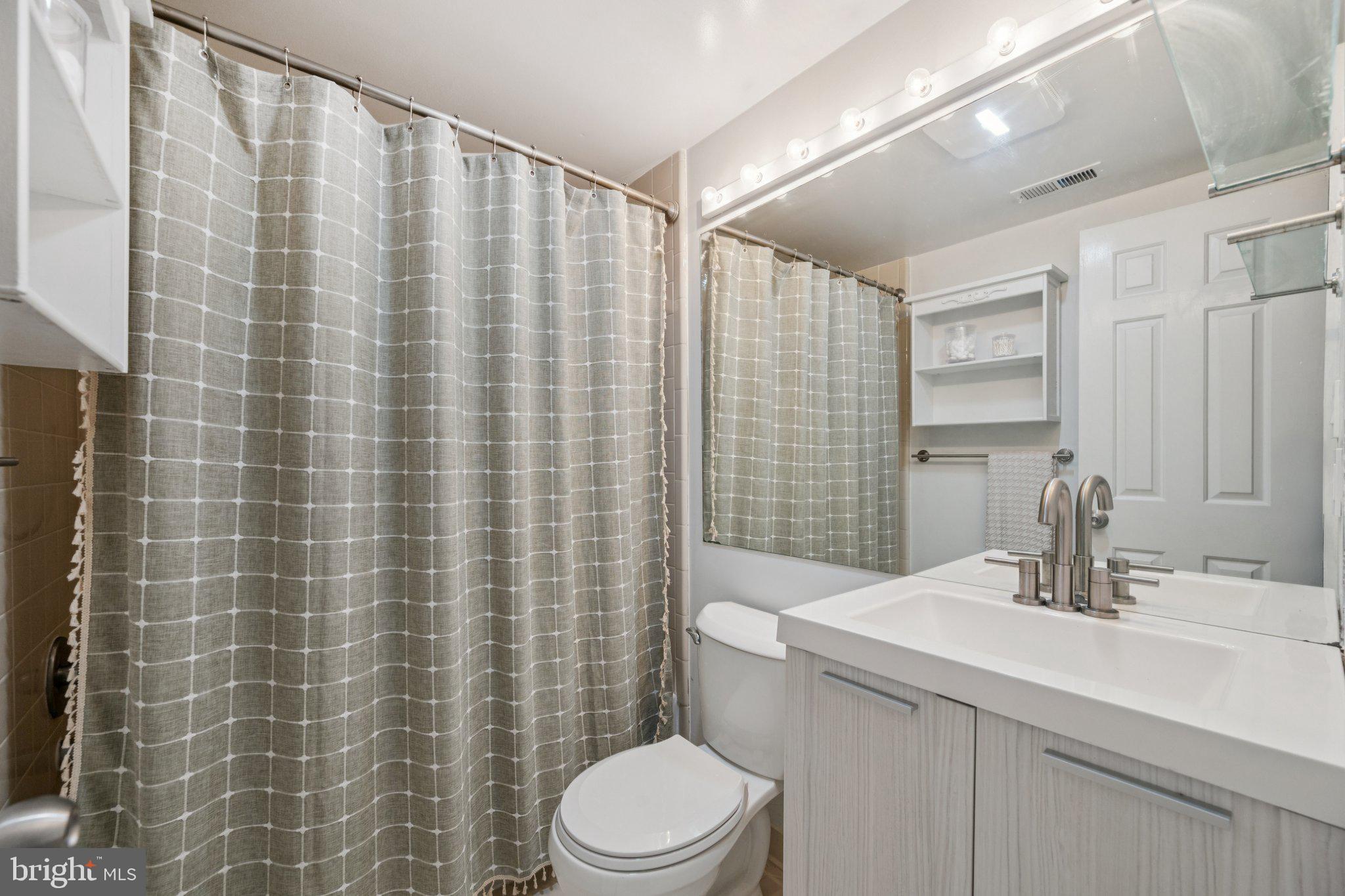 1812 Vernon Street Northwest, Unit 34 Washington, DC 20009 - Photo 18 of 26 a bathroom with a sink a toilet and shower curtain