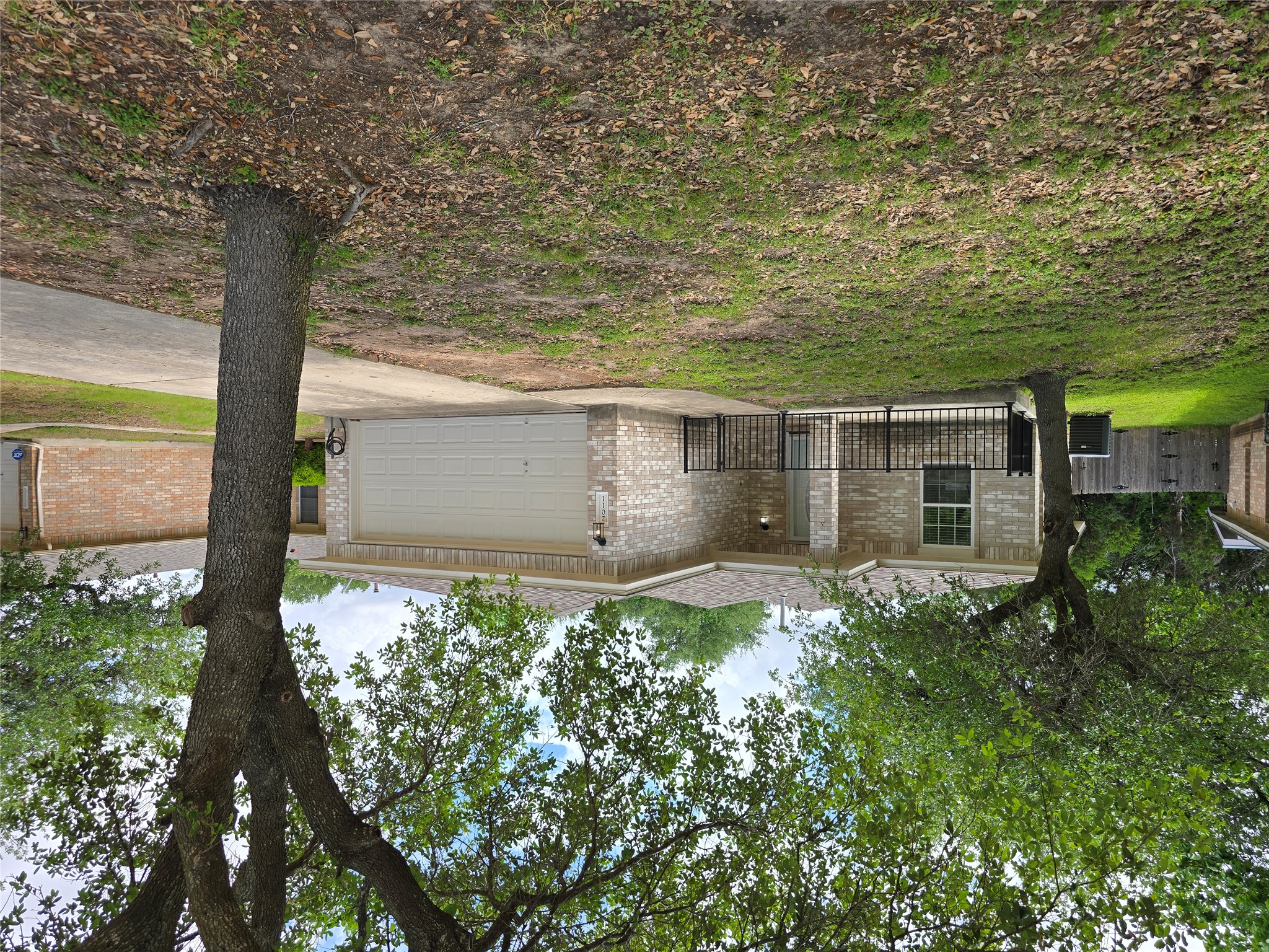 Ranch-style house featuring a garage, concrete driveway, and brick siding