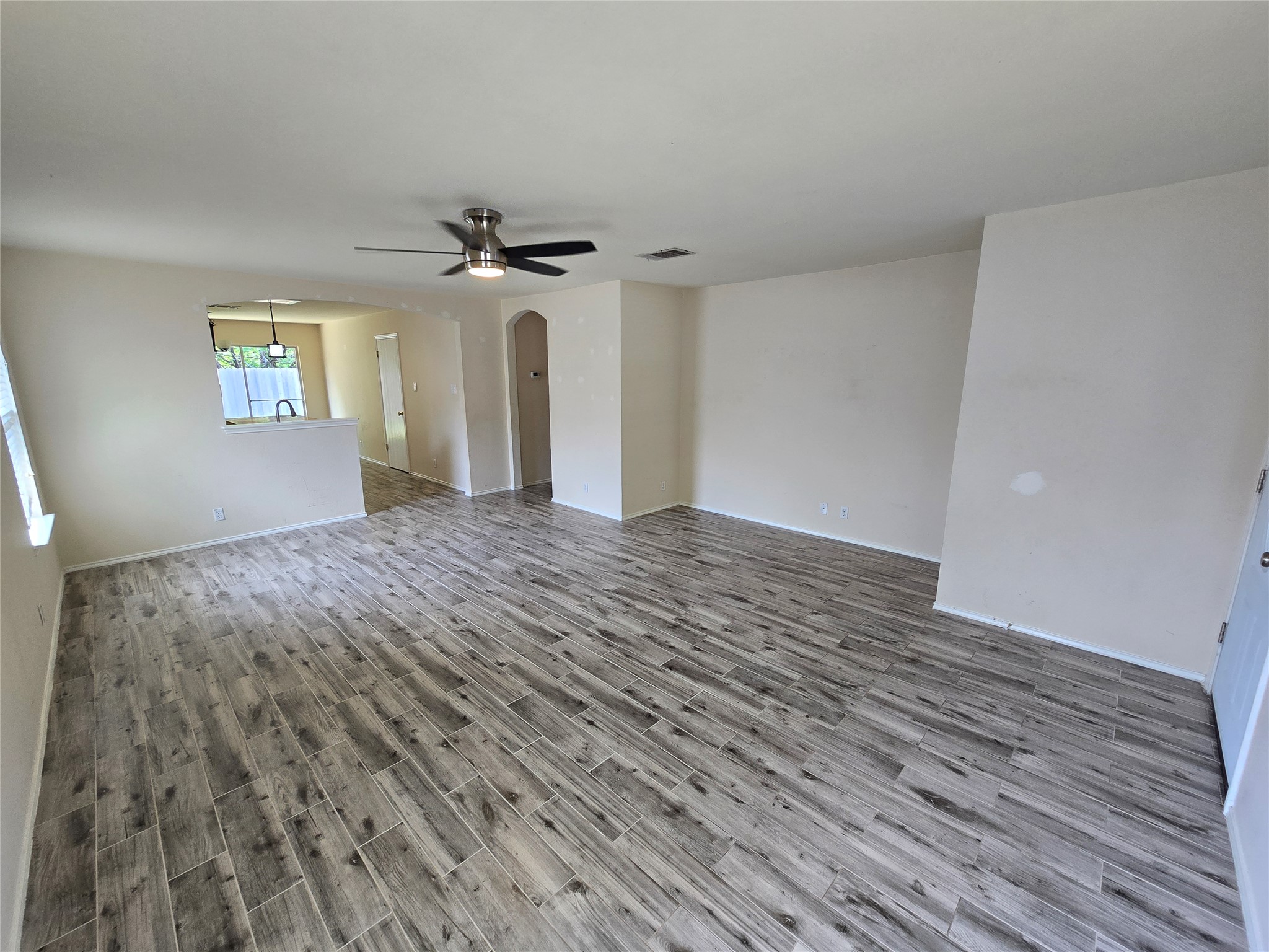 2011 Garrison Drive Leander, TX 78641 - Photo 5 of 23 Living room with arched walkways, neutral wood-style floors, and ceiling fan