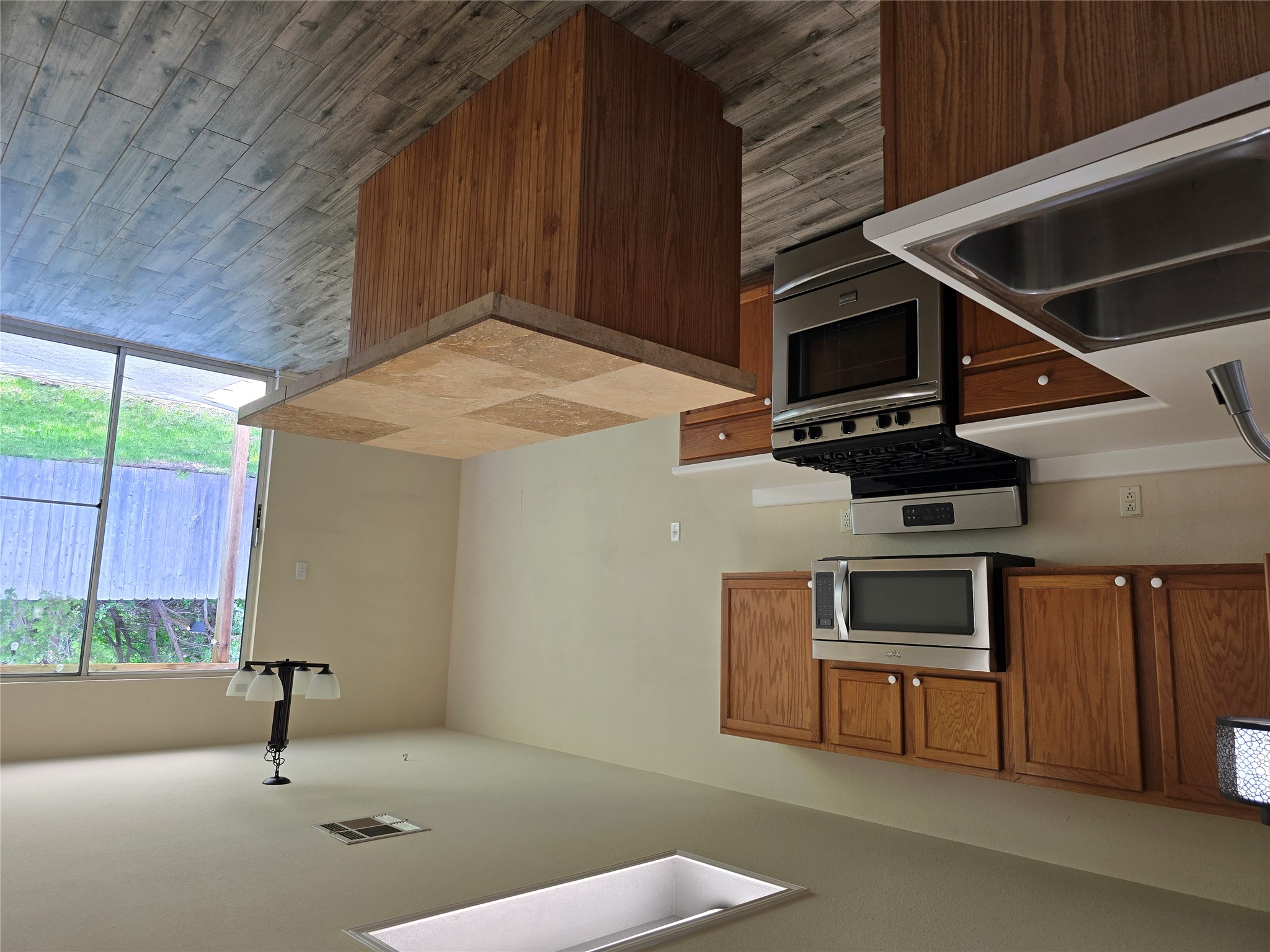 2011 Garrison Drive Leander, TX 78641 - Photo 6 of 23 Kitchen with stainless steel appliances, light countertops, wood finish cabinets, and neutral flooring