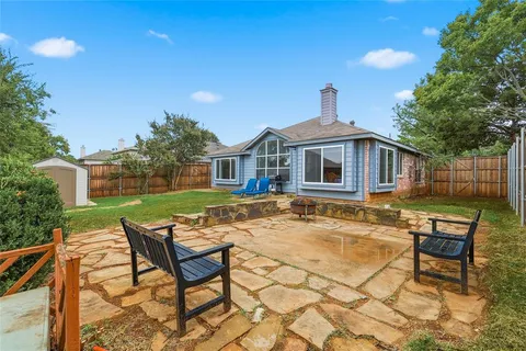a backyard of a house with table and chairs